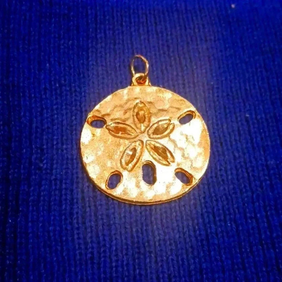 Jewelry - Pretty cool looking flower charm..gold color..sand dollar..